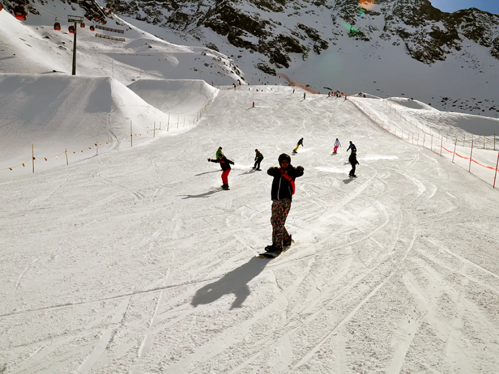Snowboarder fährt vor der Bergkulisse talwärts.
